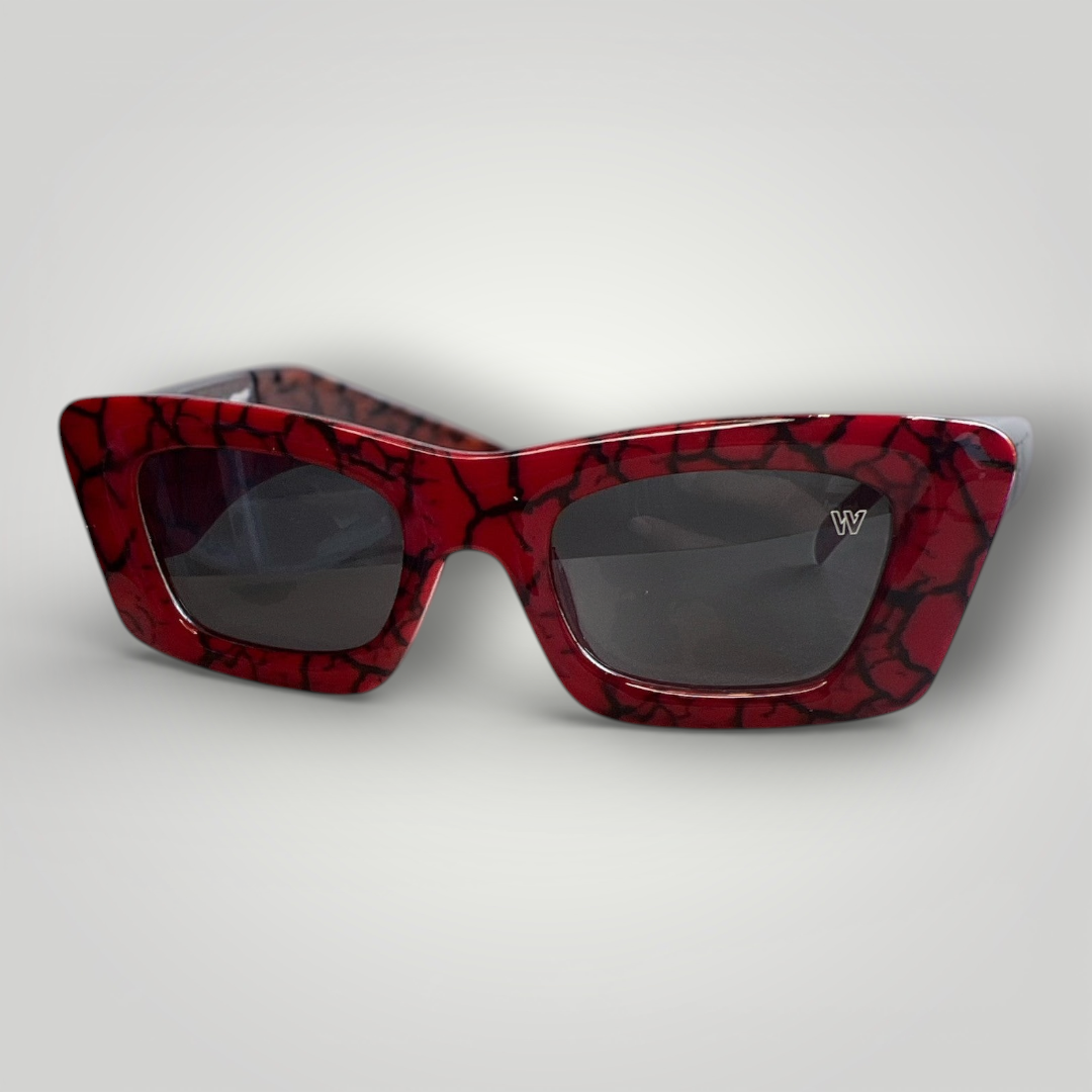 Óculos de sol W One em acetato vermelho marmorizado em preto, um modelo de tirar o fôlego, ousado e cheio de personalidade. O design gatinho traduz luxo e atitude para quem tem estilo e gosta de se destacar. No uso diário, a proteção UV400 garante conforto e segurança visual, unindo impacto estético e funcionalidade em uma peça marcante.