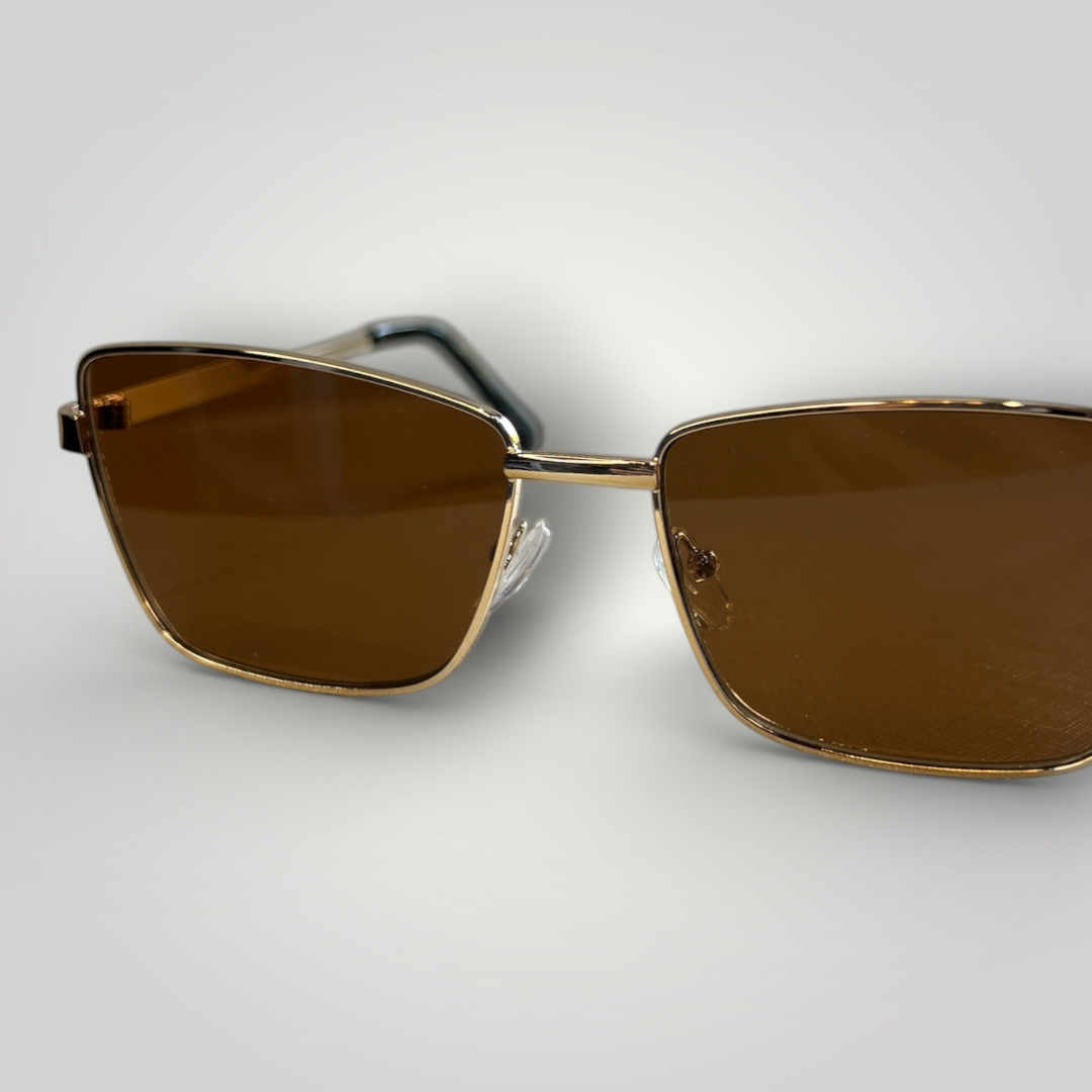 Óculos de sol W One estilo gatinho em metal dourado com lentes marrons, incondicionalmente lindo e chique. O design clássico une beleza e estilo em um modelo sofisticado, ideal para quem valoriza elegância atemporal e presença marcante. No uso diário, a proteção UV400 garante conforto e segurança visual, completando a experiência com refinamento.