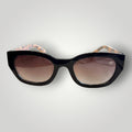 W One Brand Store black cat-eye acetate sunglasses with gradient brown lenses and orange plaid temples.