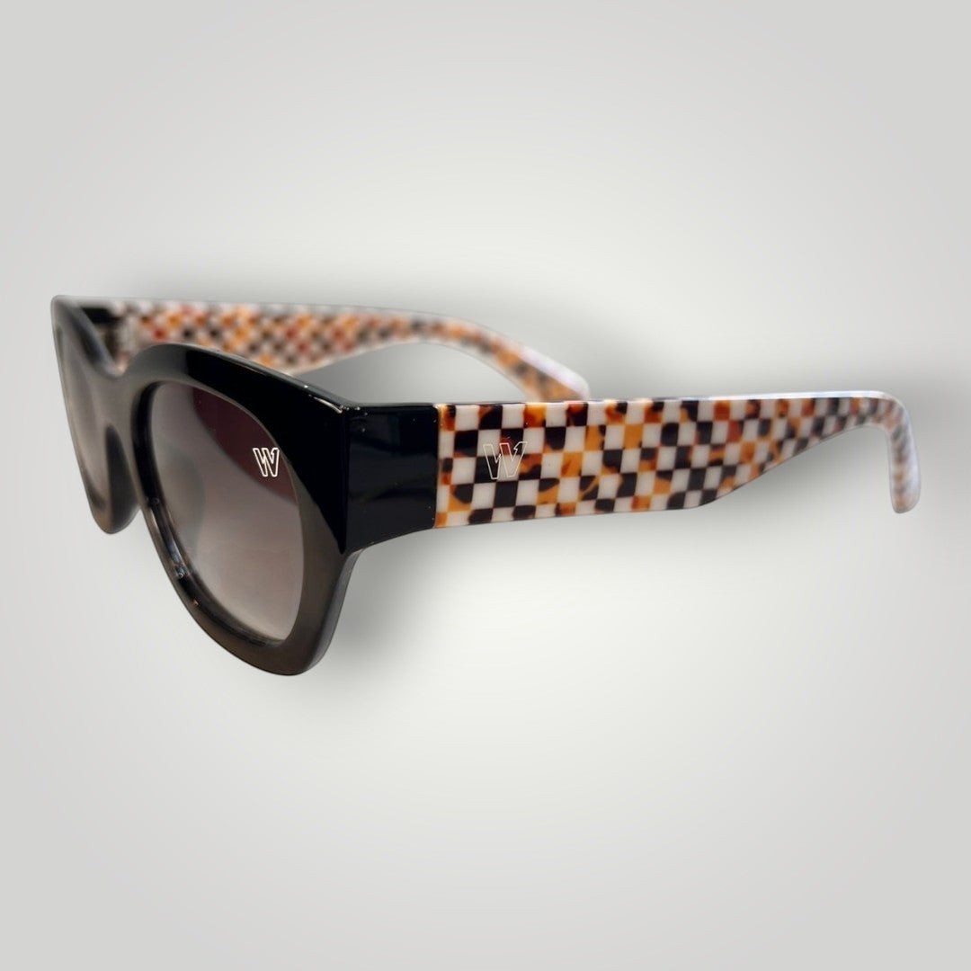 W One Brand Store black acetate cat-eye sunglasses with checkered orange arms and brown gradient lenses.