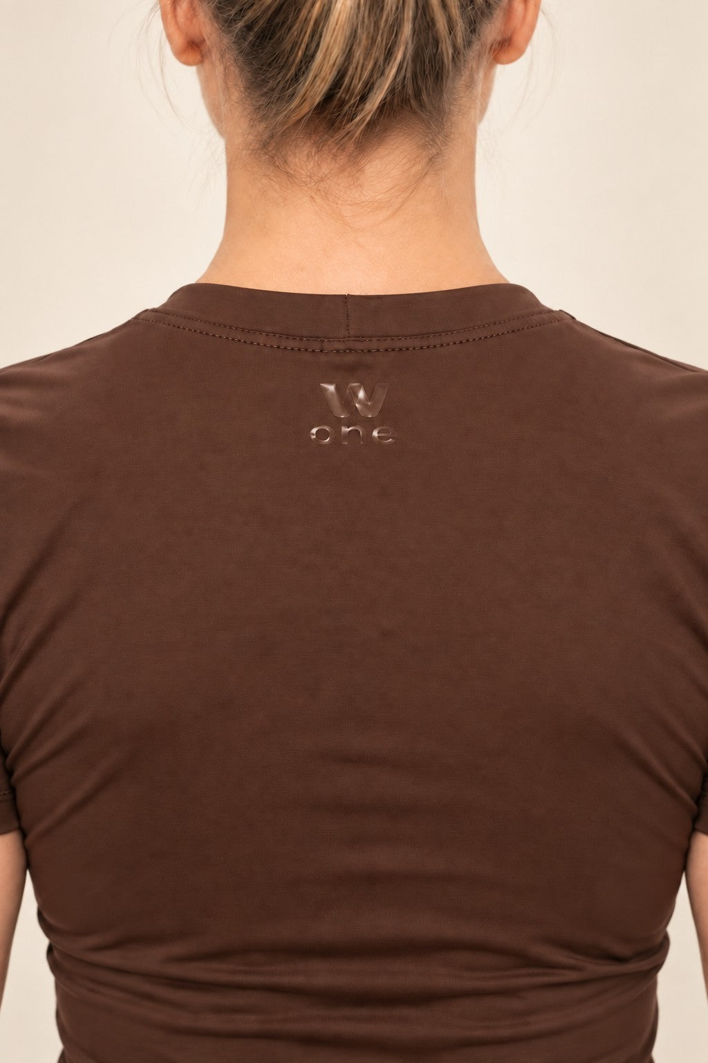 Detalhe das costas de blusa W One Brand Store na cor chocolate com logo metalizado aplicado no centro