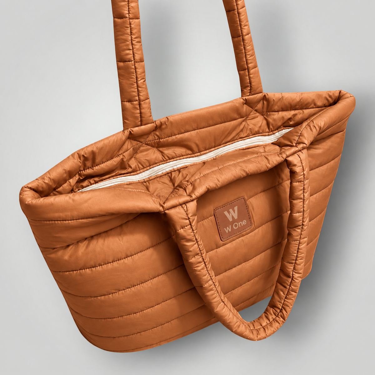 Bolsa W One Brand Store Move Puffer grande na cor caramelo com acabamento acolchoado e alças de ombro resistentes.