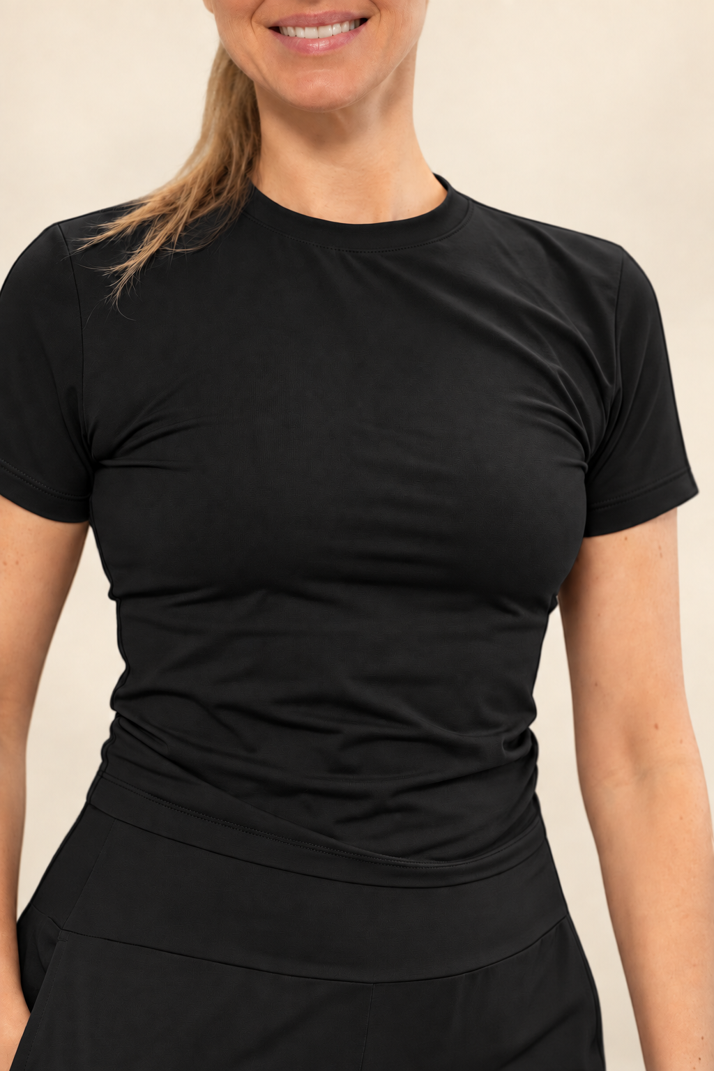 Mulher vestindo camiseta cropped preta W One Brand Store em poliamida com elastano e proteção solar FPU 50+