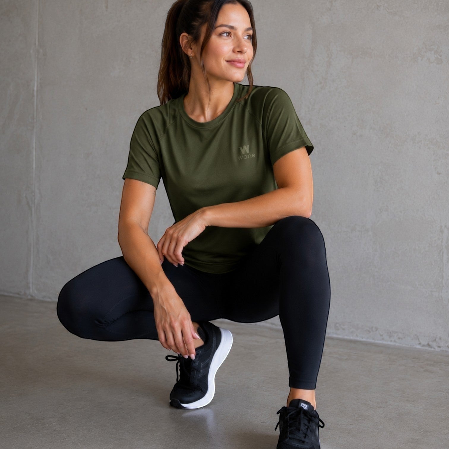 Modelo vestindo camiseta W One Brand Store verde militar com mangas raglan e tecido respirável para treinos