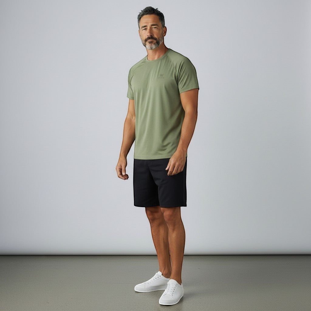 Homem vestindo camiseta W One Brand Store verde malva com recorte raglan em poliamida, combinada com bermuda preta.