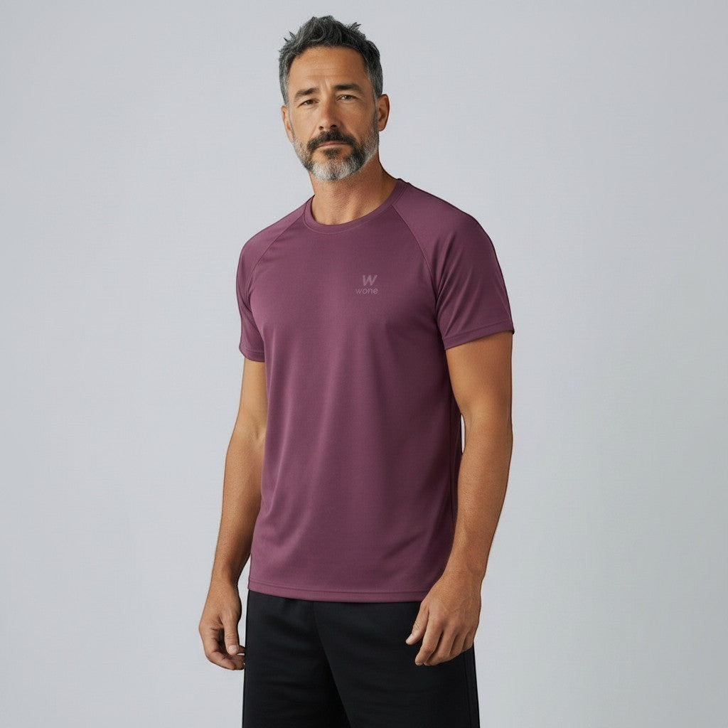 Homem vestindo camiseta W One Brand Store Dynamic Wine com mangas raglan, tecido esportivo respirável e corte reto.