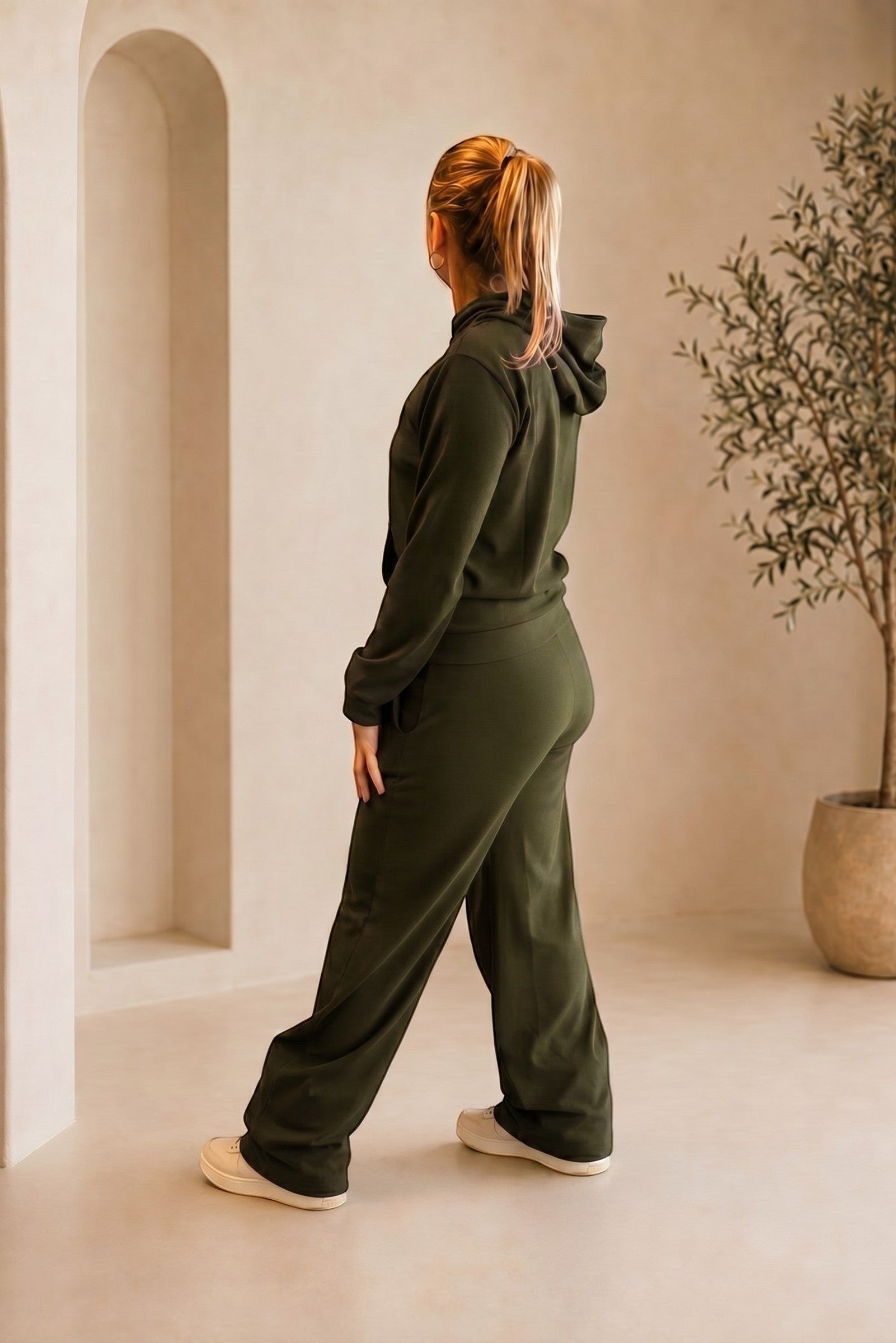 Mulher vestindo conjunto W One Brand Store verde militar canelado com blusa de capuz e calça pantalona em ambiente