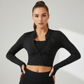 Modelo vestindo jaqueta cropped preta W One Brand Store em tecido dry fit com zíper e mangas longas com abertura