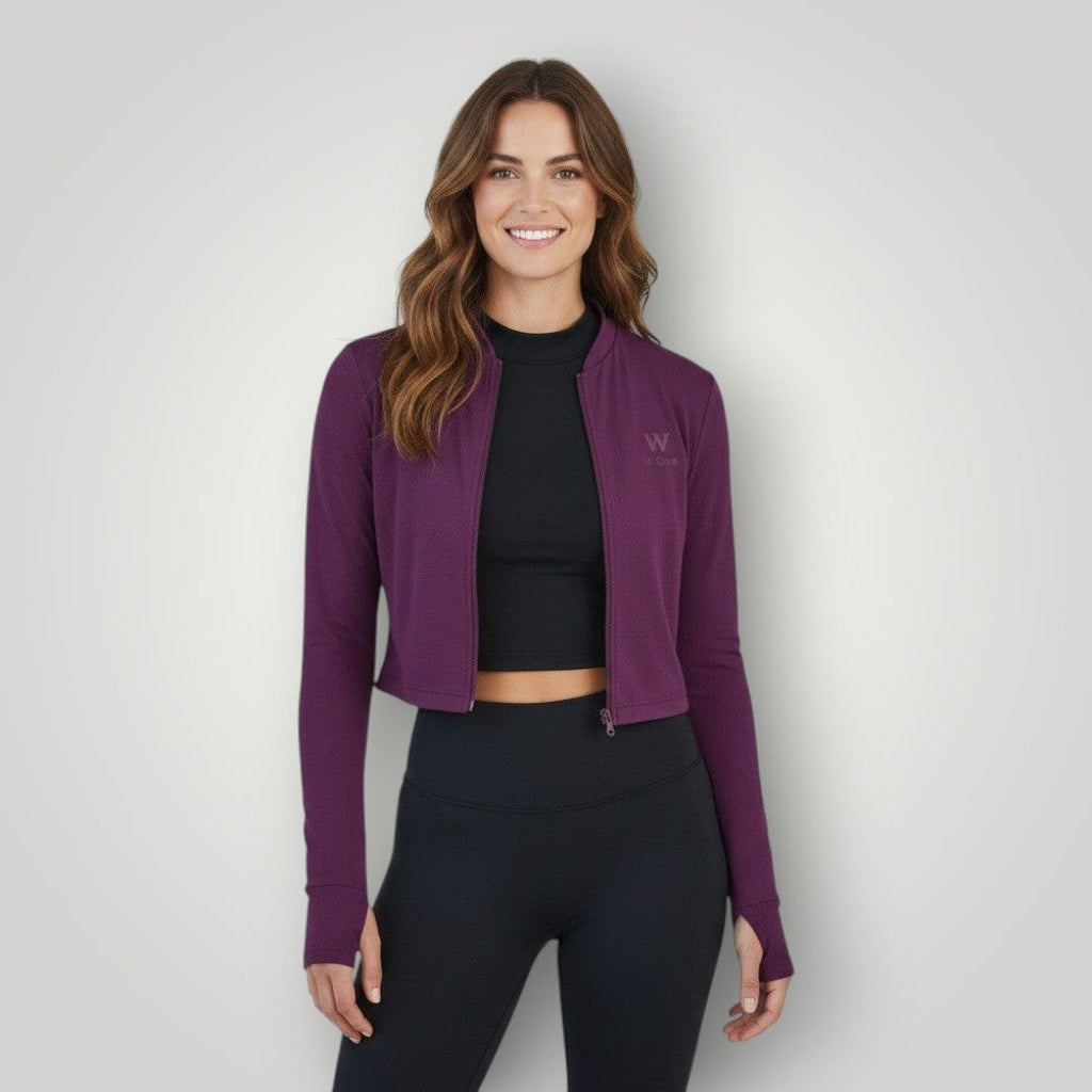 Modelo vestindo jaqueta cropped W One Brand Store cor vinho em tecido dry fit com zíper e ajuste confortável