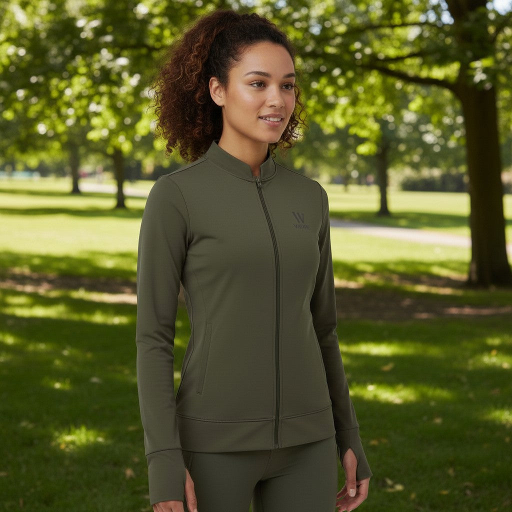 Modelo vestindo jaqueta W One Brand Store verde militar com zíper e abertura para dedos em parque arborizado