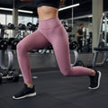 Legging W One Brand Store Essence na cor cacau, com média compressão e tecido respirável, em ambiente de academia.