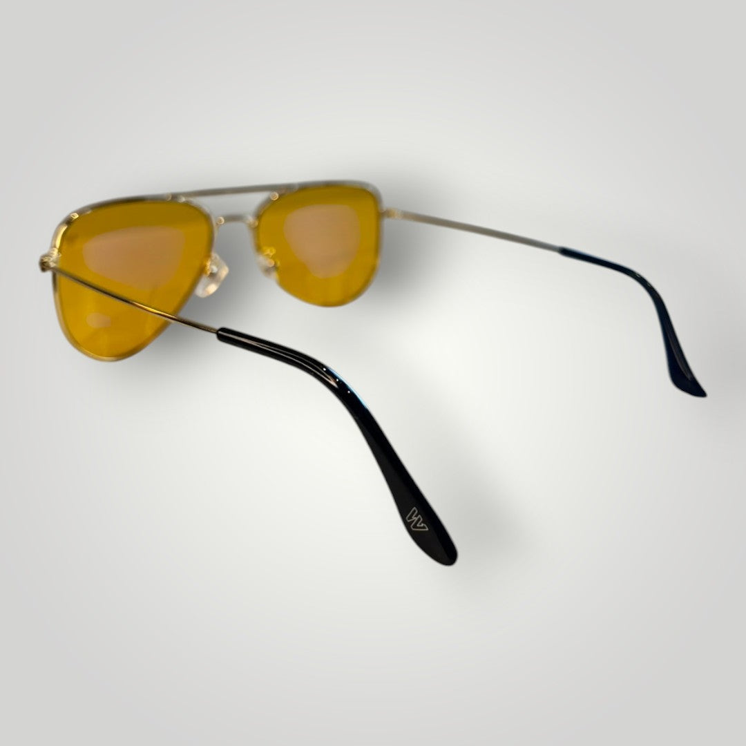 Óculos de sol aviador W One Brand Store com armação de metal dourado e lentes amarelas, hastes com ponteiras pretas.
