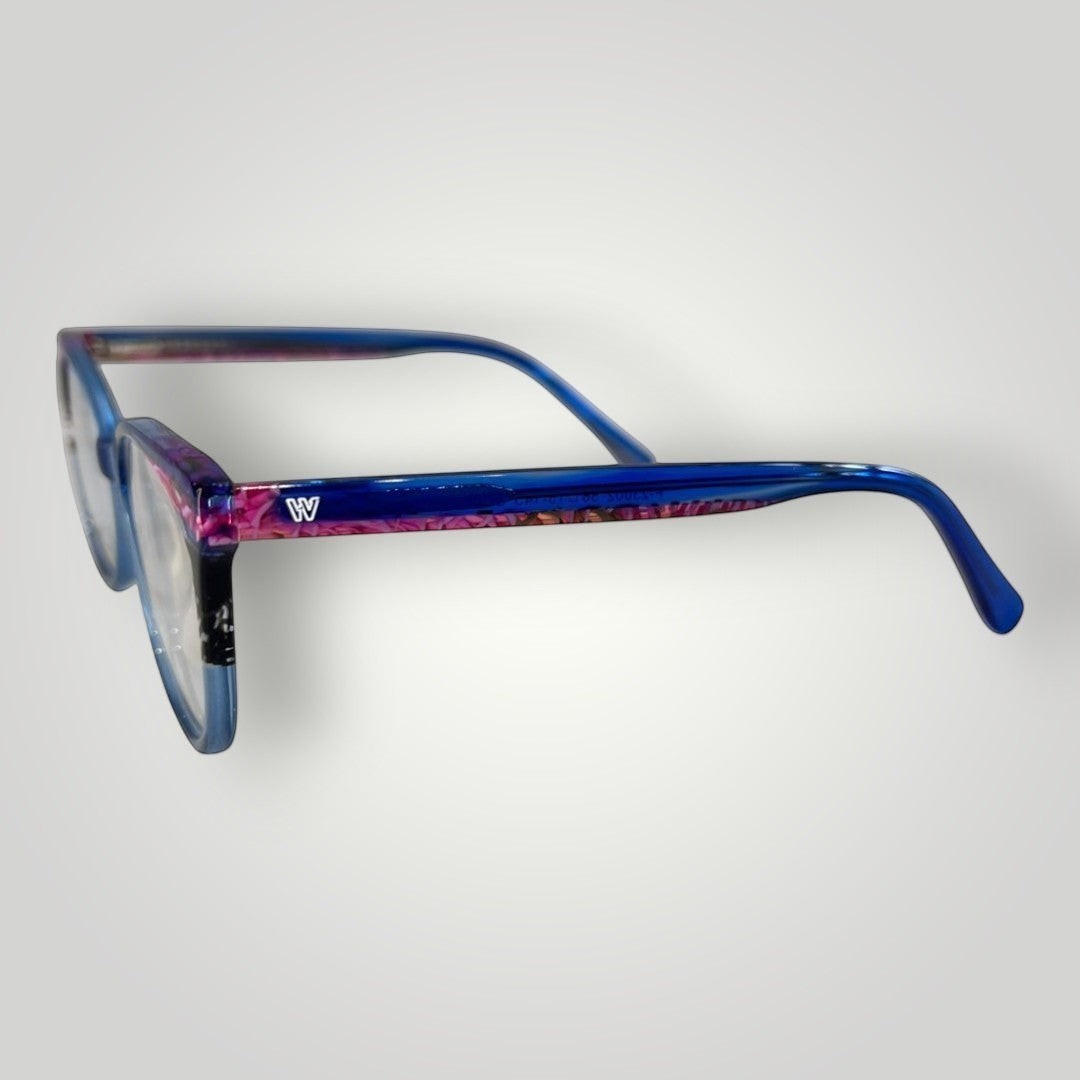 Óculos de grau W One Brand Store gatinho em acetato azul escuro transparente com detalhes rosas e armação moderna.