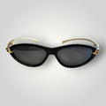 Óculos de sol W One gatinho em acetato preto com detalhe de nó em metal dourado e lentes fumê.