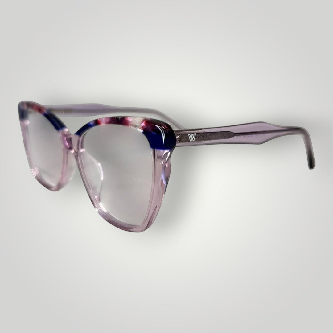 Óculos de grau W One em acetato lilás com detalhes superiores e pontas das hastes fumê, armação moderna e elegante.
