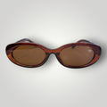 Óculos de sol W One Brand Store com armação oval em acetato marrom e lentes marrons com proteção UV400.
