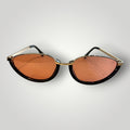Óculos de sol W One Brand Store ovais em metal dourado e acetato preto com lentes rosas, design moderno e elegante.