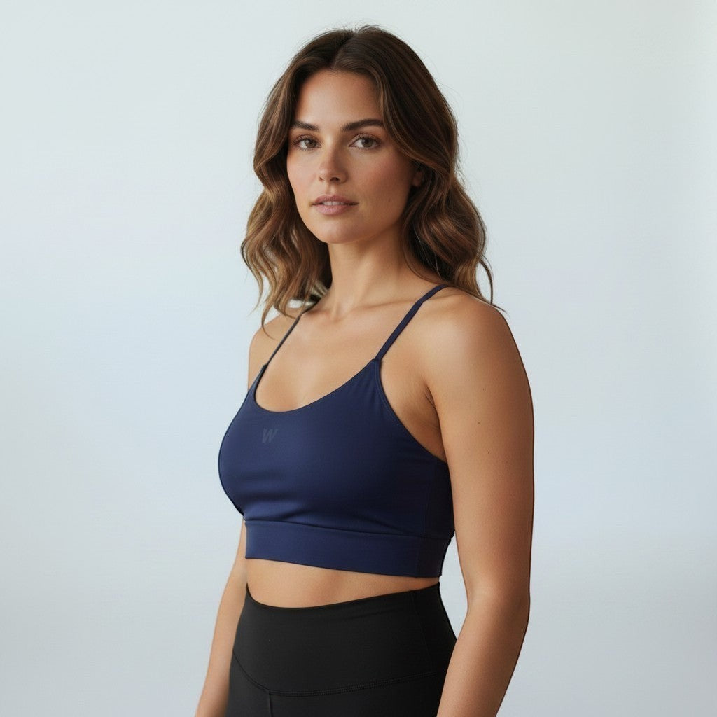 Modelo vestindo top esportivo W One Brand Store azul marinho com alças fixas e média sustentação em tecido macio