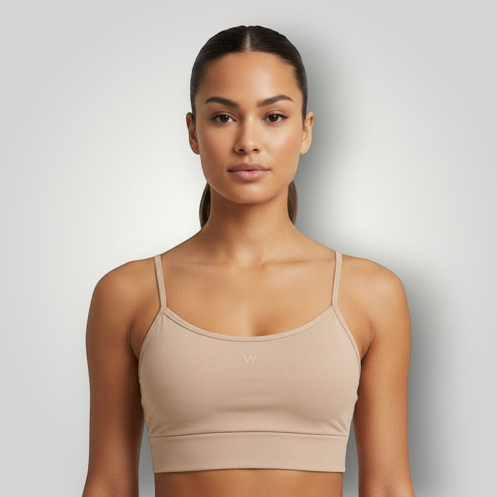 Modelo vestindo top esportivo W One Brand Store cor canela com alças reguláveis e média sustentação