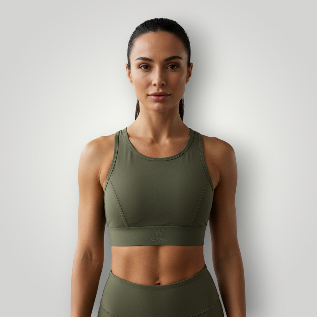 Modelo vestindo top esportivo W One Brand Store verde militar de alta sustentação com tecido respirável e ajuste firme