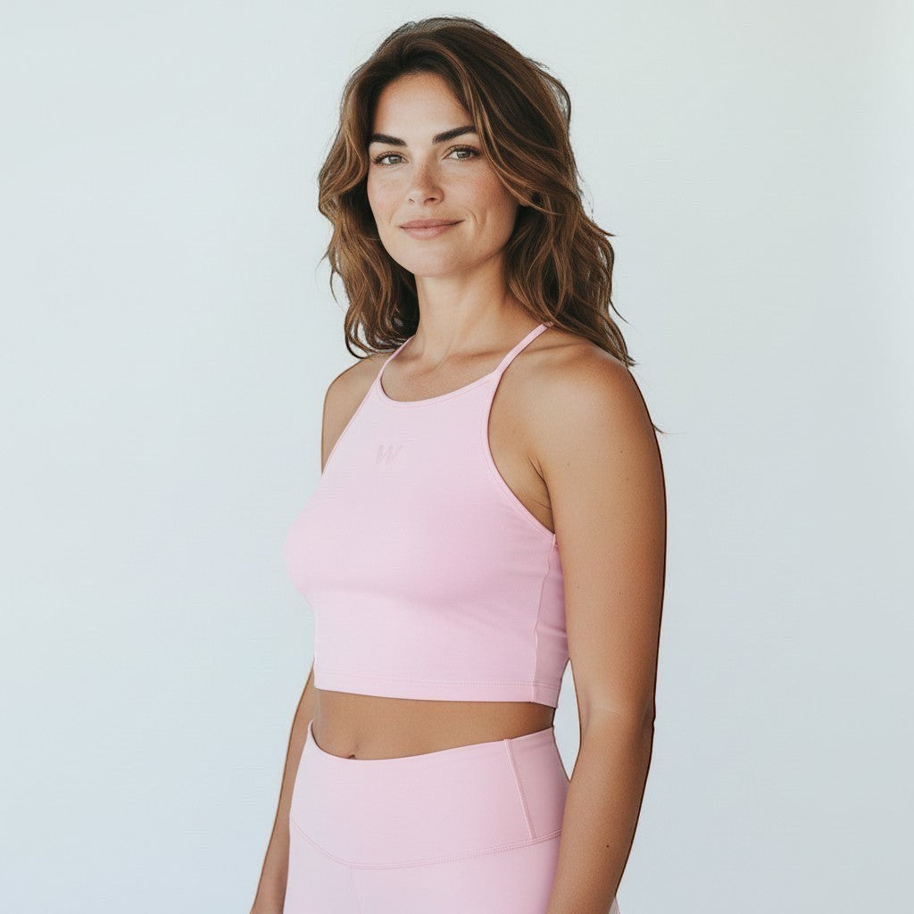 Modelo vestindo top fitness W One Brand Store rosa balé com frente alta e média sustentação em tecido macio