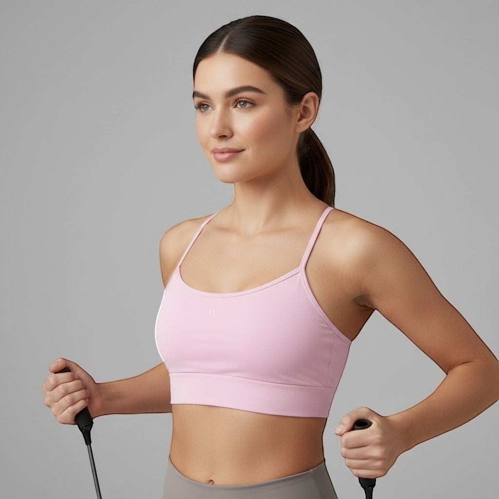 Modelo vestindo top W One Brand Store rosa balé com alças reguláveis e média sustentação para treinos