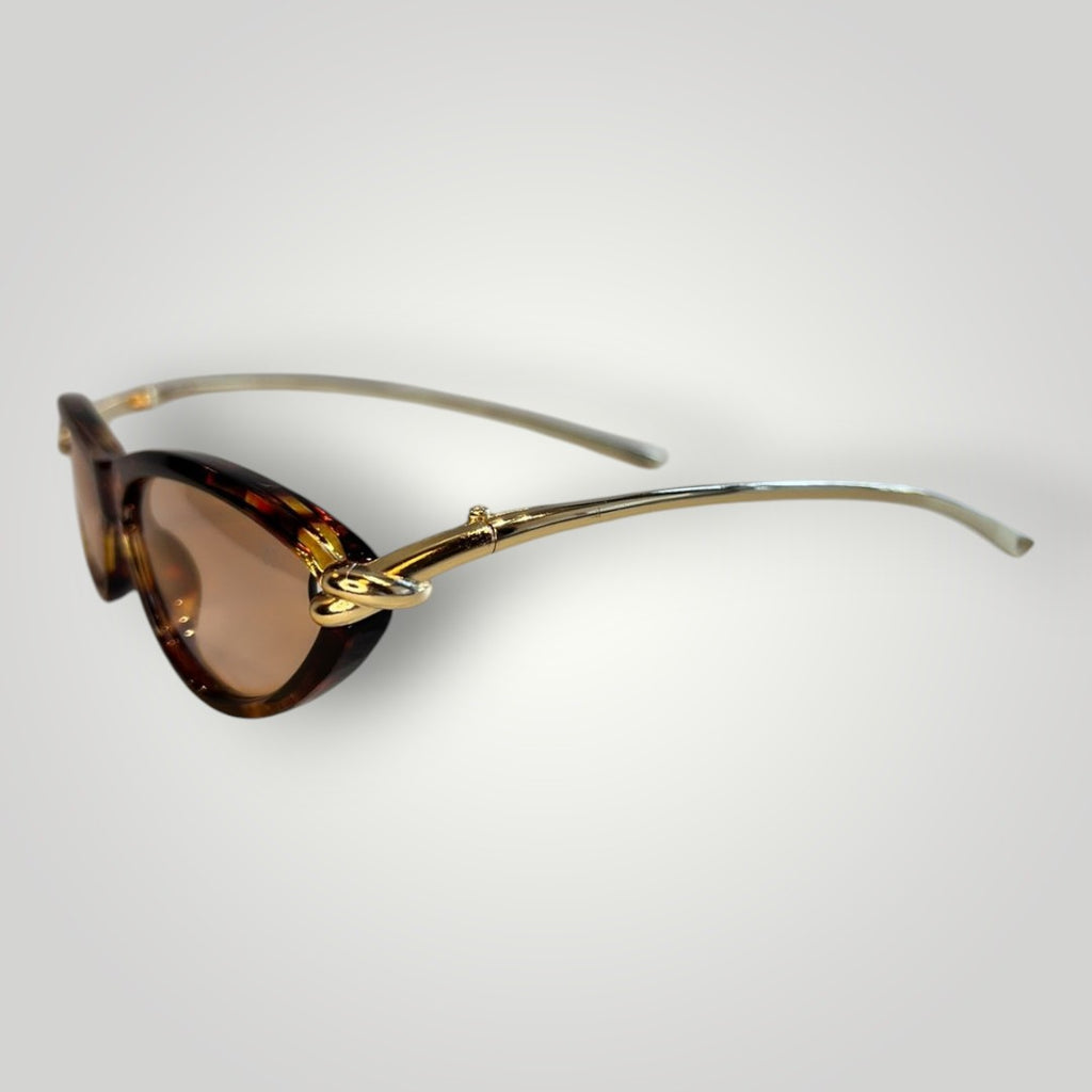Óculos de sol W One gatinho em acetato camuflado com haste dourada e lentes rosas. Detalhe de nó na haste.